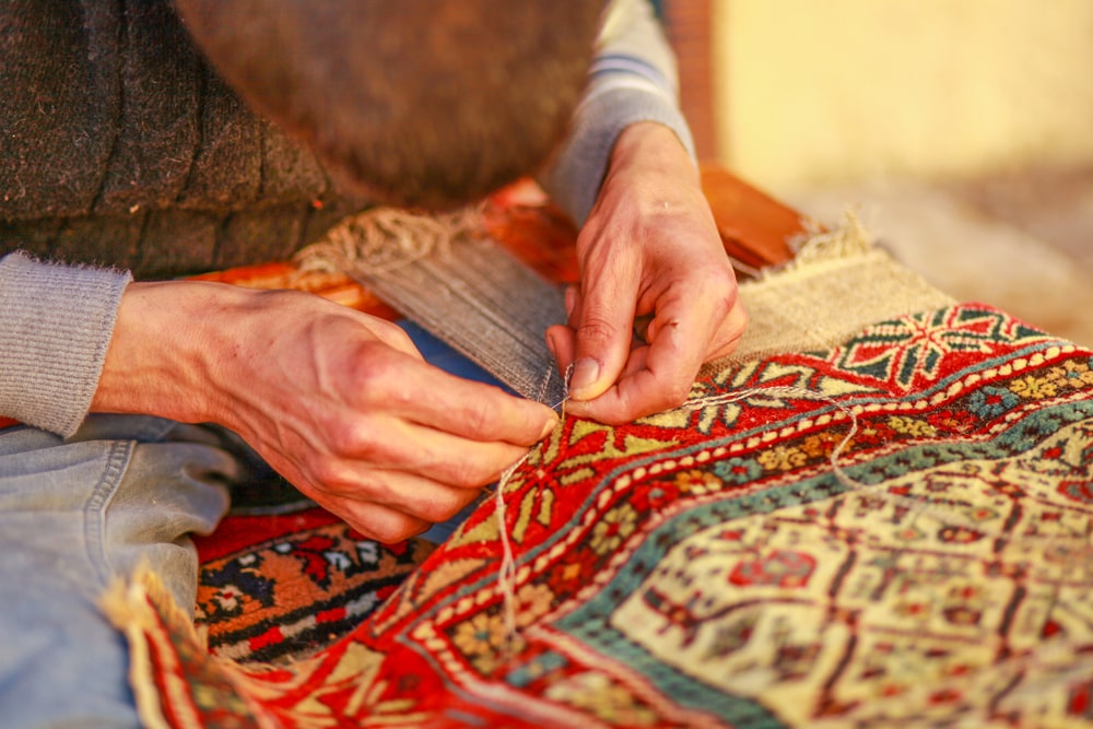 Why is hand-woven carpet more expensive than machine-made carpet?